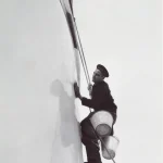 Homme lavant un navire avec des seaux suspendus