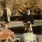 Enfant jouant avec une voiture à pédales dans un parc automnal