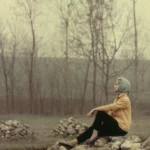Femme assise sur un tas de pierres dans un paysage d'hiver