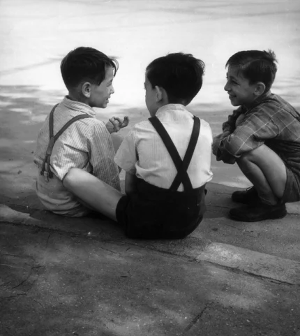 Trois garçons discutant assis près d'un plan d'eau