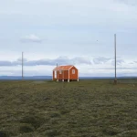 Petite maison rouge au milieu d'une vaste plaine