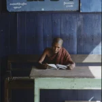 Moine lisant dans une salle en bois