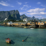 Village côtier avec maisons colorées et montagnes en arrière-plan