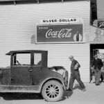Scène de rue avec une ancienne voiture et des passants devant un magasin de boissons