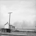 Maison isolée près de rails de chemin de fer avec poteau téléphonique