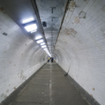 Tunnel souterrain éclairé avec personnes marchant au loin