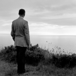 Homme seul contemplant l'horizon maritime