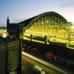 Gare illuminée au crépuscule avec trafic routier
