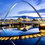 Pont illuminé sur une rivière au crépuscule
