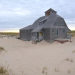 Maison en bois sur dune de sable