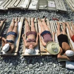 Femmes bronzant sur des galets