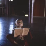 Jeune moine en méditation avec un livre dans un temple