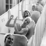 Femmes s'amusant sous la douche dans des cabines individuelles