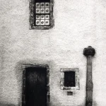 Façade ancienne avec porte en bois et fenêtres grillagées