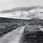 Chemin de campagne sinueux sous ciel nuageux