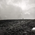 Paysage de champ labouré sous un ciel nuageux