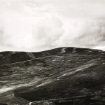 Paysage montagneux en noir et blanc avec ciel nuageux