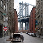 Femme vérifiant voiture sous pont Manhattan Bridge à New York