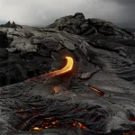 Coulée de lave en fusion sur terrain rocheux