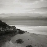 Paysage côtier noir et blanc avec montagnes et plage
