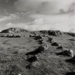 Paysage de collines rocheuses sous un ciel nuageux