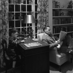 Enfant jouant tandis qu'un homme lit dans un bureau à domicile