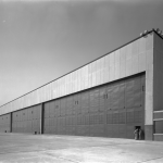Grand Hangar Industriel avec Deux Hommes