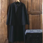 Manteau noir suspendu sur une porte en bois