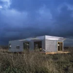 Maison moderne en métal sous un ciel orageux