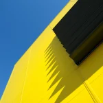 Architecture moderne avec ombres géométriques sur un bâtiment jaune