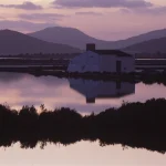 Lever de Soleil sur une Maison Isolée près d'un Lac