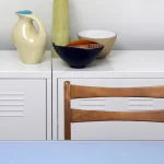 Arrangement de vases et bols sur un meuble avec chaise