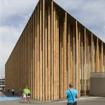 Bâtiment moderne avec passants devant des colonnes verticales