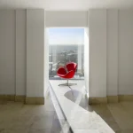 Chaise rouge dans une pièce lumineuse avec vue sur la ville