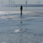 Silhouette face aux éoliennes sur la plage