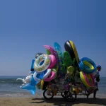 Vendeur ambulant de jouets de plage au bord de mer.