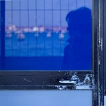 Reflet d'une silhouette sur une porte vitrée bleue