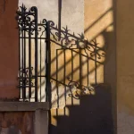 Ombre sur un mur avec grille en fer forgé