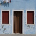 Façade bleue avec portes et fenêtres de couleur rouge