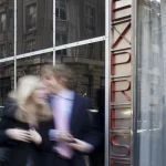 Couple flou passant devant la vitrine d'un bâtiment