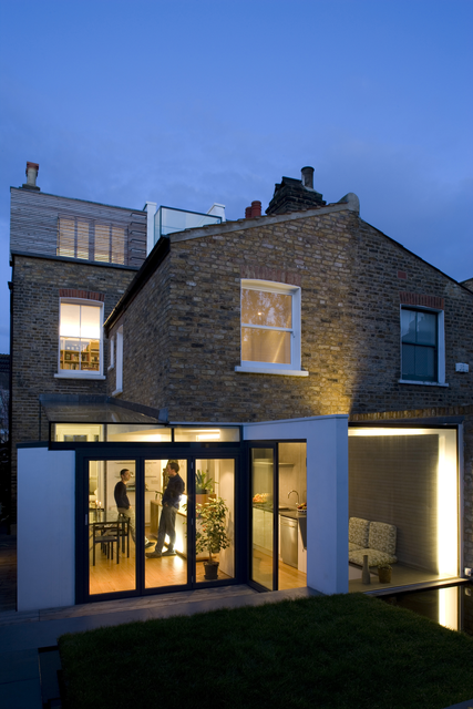 AKG5380246.webp Maison moderne en soirée avec lumière intérieure – Image 1