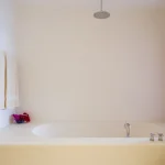 Salle de bain minimaliste avec serviettes et fleurs