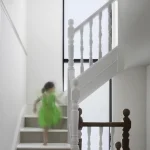 Enfant en robe verte montant les escaliers