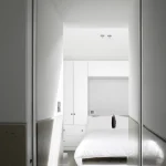 Chambre moderne avec lit blanc et armoires intégrées