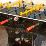 Babyfoot vintage avec barres colorées en jaune et bleu