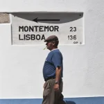 Homme marchant près d'un panneau indiquant Montemor et Lisboa