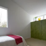 Chambre minimaliste avec armoire verte et fenêtre