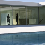 Conversation près d'une piscine moderne à travers une vitre