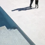 Deux personnes marchant près d'une piscine