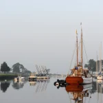 Voiliers et bateaux amarrés dans une marina calme au petit matin